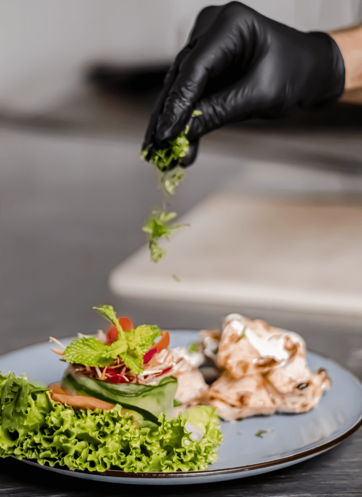 Chef finishing a fresh Masala dish with herbs